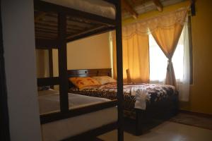 1 dormitorio con 2 literas y ventana en SOL DE PIEDRA, en Papallacta
