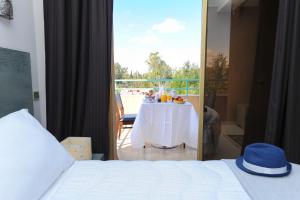 Appart-Hotel Amina Resort في مراكش: غرفة نوم مع طاولة وإطلالة على شرفة