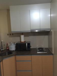 a kitchen with white cabinets and a microwave at Love This Place in Manila +10 photos
