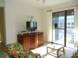 a living room with a tv and a chair at APARTAMENTO 3 dormitorio VISTA PARA MAR in Bombinhas