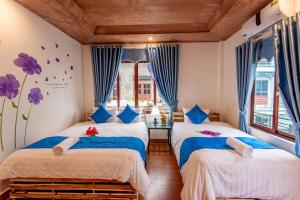 two beds in a room with blue curtains at Khai Yen Tam Coc Hostel in Ninh Binh