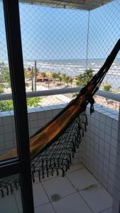a hammock hanging from a window in a bathroom at Apto Verde Água in Mongaguá