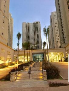 a group of benches in front of a building with tall buildings at Flat de luxo São Paulo - Guarulhos in Guarulhos