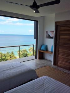 a bedroom with a large window with a view of the ocean at St Barth Villas in Salad Beach