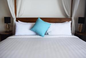 a bed with blue and white pillows on it at St Barth Villas in Salad Beach