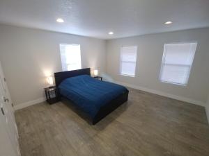 a bedroom with a blue bed and two windows at Mountain Place in Groveland