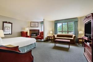 um grande quarto de hotel com uma cama e uma lareira em Harrison Lake Hotel em Harrison Hot Springs