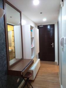 uma casa de banho com um espelho e um lavatório com uma cadeira em Abreeza Place Tower1 by Chriza em Davao