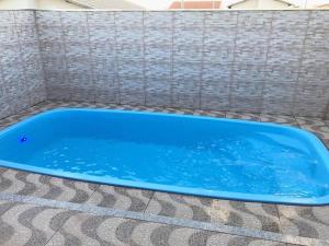 uma banheira azul num piso de azulejo em Casa temporada Aroeira em Olímpia