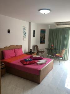 a bedroom with a large bed with pink sheets at View Talay 1B Pattaya Jomtien in Pattaya South