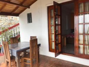 a dining room with a table and chairs next to a door at The Mist Holiday Bungalow in Haputale