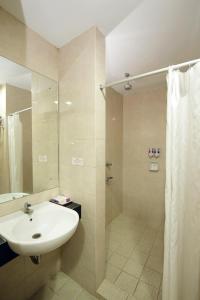 a bathroom with a sink and a shower at University Club (UC) Hotel UGM in Yogyakarta