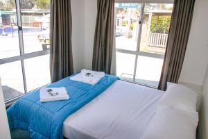 - un lit avec serviettes dans une chambre avec fenêtre dans l'établissement Ingenia Holidays Shoalhaven Heads, à Shoalhaven Heads