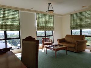 
a living room filled with furniture and a window at Merdeka Palace Hotel & Suites in Kuching
