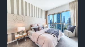 a bedroom with a large bed and a large window at Artique Surfers Paradise - Official in Gold Coast