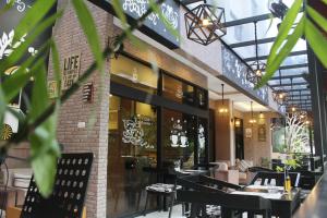 a restaurant with tables and chairs in a building at Grand Inna Tunjungan in Surabaya