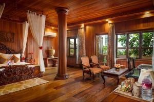 una camera da letto con un letto, un tavolo e delle sedie di Ta Prohm Hotel & Spa a Siem Reap