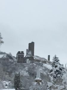 an old castle on a hill in the snow at Ferienwohnung Am Elzbach in Monreal