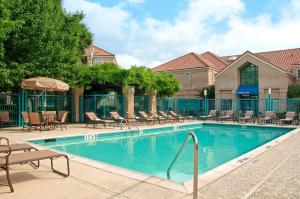 una gran piscina con sillas y mesas en Hyatt House Dallas Addison, en Addison