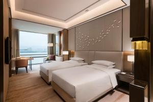 two beds in a hotel room with a view at Hyatt Regency Fuzhou Cangshan in Fuzhou
