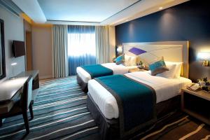 a hotel room with two beds and a desk at Al Sarab Hotel in Dubai +90 photos