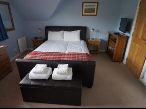 1 dormitorio con 1 cama y 2 toallas blancas en Trotternish B&B, en Portree