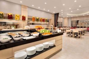 uma linha de buffet com pratos e tigelas de comida em TRYP by Wyndham Izmit em Cocaeli