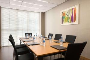 Una sala de conferencias con una larga mesa de madera y sillas. en TRYP by Wyndham Abu Dhabi City Center, en Abu Dabi