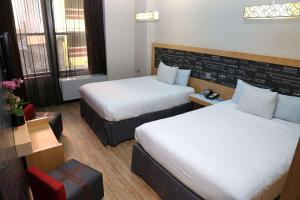 a hotel room with two beds and a chair at TRYP by Wyndham New York City Times Square - Midtown in New York