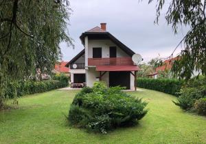 a house with a red roof in a yard at Mária Villa in Balatonmáriafürdő