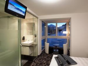 a hotel room with a bathroom with a sink and a window at Ischglliving Appartements in Ischgl