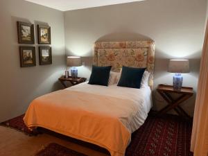 um quarto com uma cama com cabeceira e 2 candeeiros em Cavalo Guesthouse & Equestrian Estate em Drummond