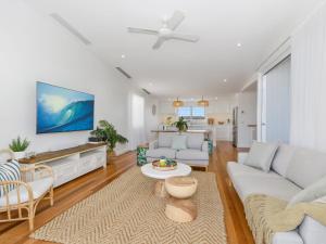 a living room with a couch and a table at Marine Beach House in Kingscliff
