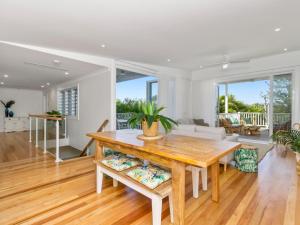 a dining room with a table and a couch at Marine Beach House in Kingscliff