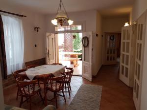 a dining room with a table and chairs and an open door at Boronaház Fogadó in Szalafő