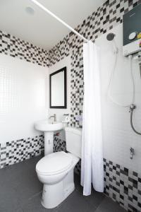 a bathroom with a white toilet and a sink at House of Happiness in Bangkok