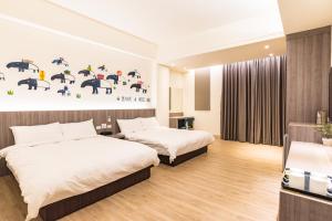 ein Hotelzimmer mit 2 Betten und einer Wand mit Sonnenschirmen in der Unterkunft Rhino Guest House in Hualien