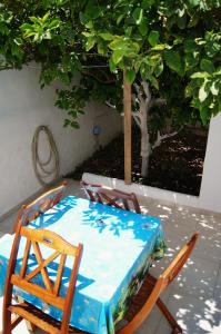 a table and chairs with a table and a tree at Giannis Hotel Apartments in Adamantas