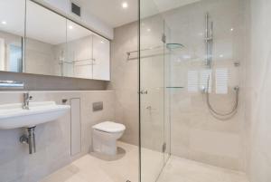 a bathroom with a shower and a toilet and a sink at Wharf Lodge River View Apartment in Maroochydore