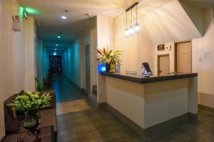 Una donna seduta al bancone in un atrio dell'ospedale di ETT HomeTel a Kalibo