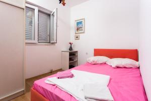 1 dormitorio con cama rosa y ventana en Apartment Eleonora, en Dubrovnik