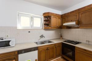 una cocina con armarios de madera y fregadero en Apartment Eleonora, en Dubrovnik