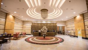 a lobby of a hotel with a large chandelier at La Suite Dubai Hotel & Apartments in Dubai