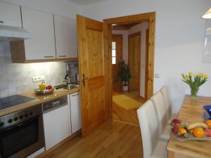 a kitchen with a wooden door and a table at Ferienwohnung Ronacher in Abtenau