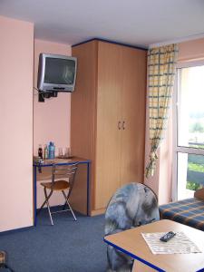 a living room with a couch and a table and a tv at HOSTEL SUCHY BÓR in Suchy Bór