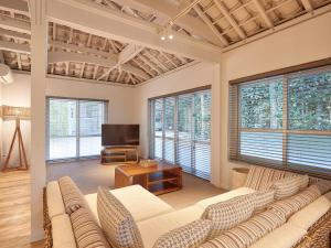 a living room with a couch and some windows at ADAN RESORT 太陽 - Tida - in Bise