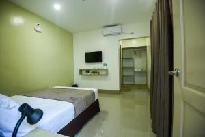 a hotel room with a bed and a television at ETT HomeTel in Kalibo +35 photos