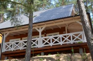 a log cabin with a gambrel roof at Domki Kaszuby - jezioro las i zoo w Szarlocie in Kościerzyna