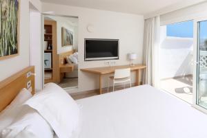 a living room with a television and a bed at Iberostar Selection Lanzarote Park in Playa Blanca
