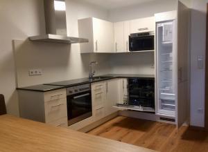 a kitchen with white cabinets and a sink and a refrigerator at Kitzbuheler Alpen Residenz Top2 Hollersbach in Hollersbach im Pinzgau